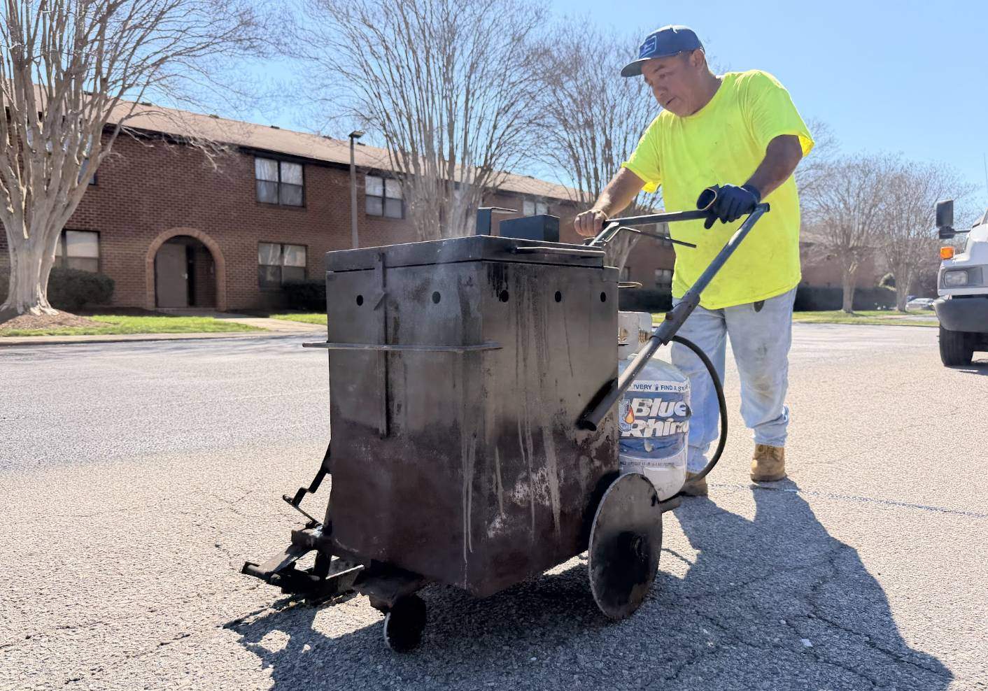 A.J. & Son Asphalt Paving contractor operating a hot rubberized crack filling machine on a parking lot in Kinston NC.
